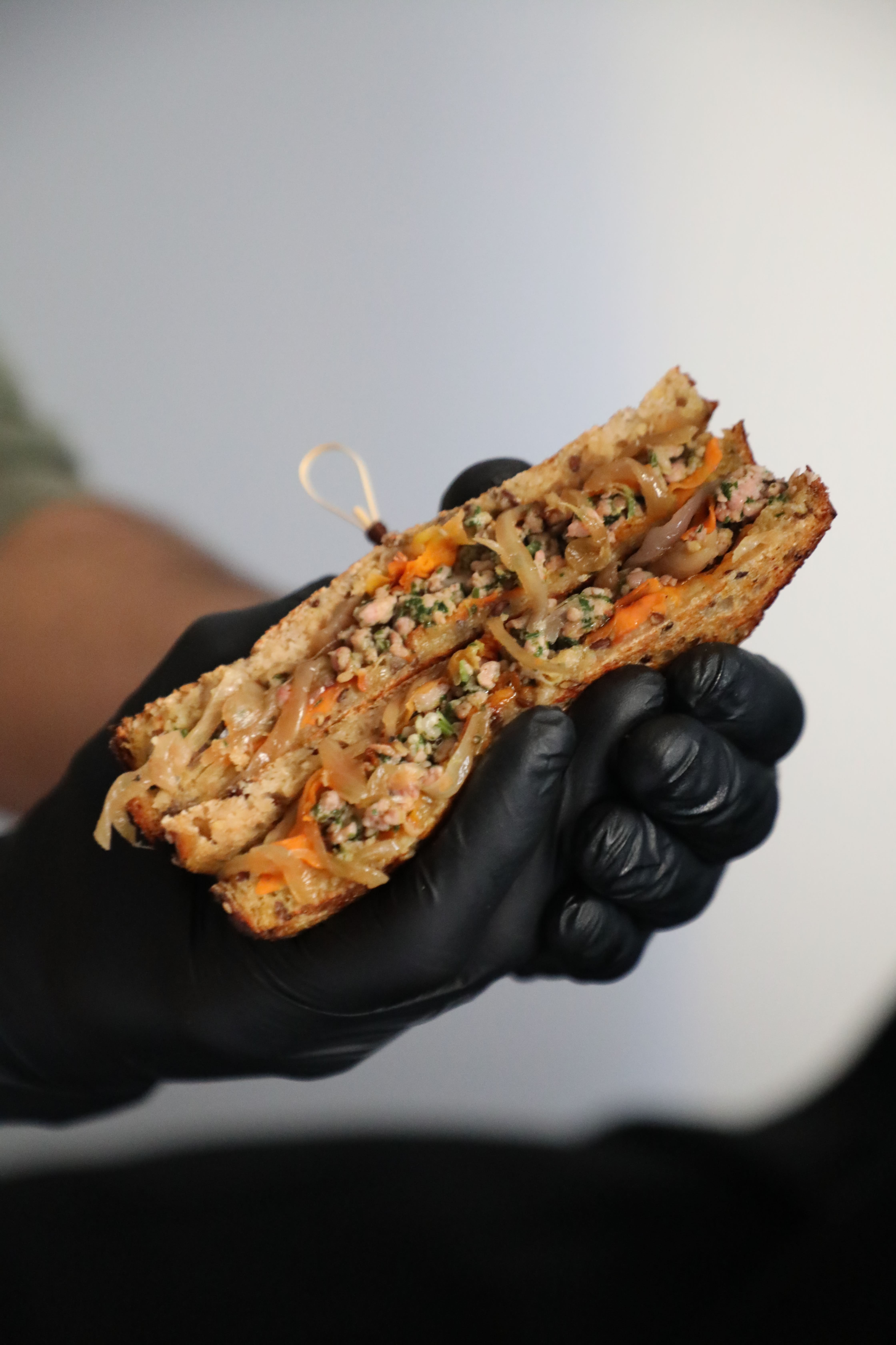 Club toasté Véronique : pain levain bio aux graines, haché de poulet mariné aux herbes fraîches et épices, confit d'oignons, tagliatelles de carottes